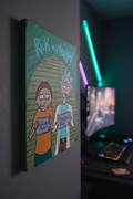 Close-up of handmade Rick and Morty canvas painting displayed in a gaming room with LED lights